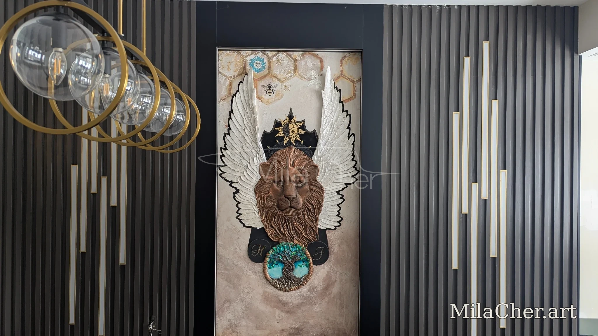 Winged lion sculptural relief installed within a dark architectural wall with gold accents